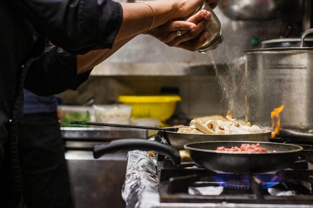 Chef seasoning food in a professional kitchen
